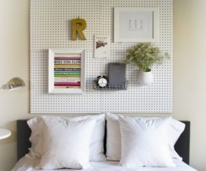 Bedroom with pegboard headboard with white pillows and Eclectic Accents